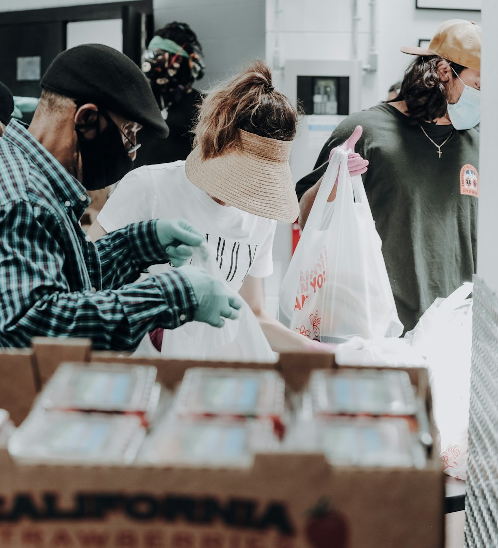 Neighbors and volunteers handing out food and supplies to one another at a community distribution